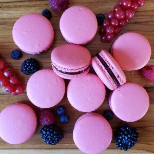 Berry jasmine macarons with berries on a table